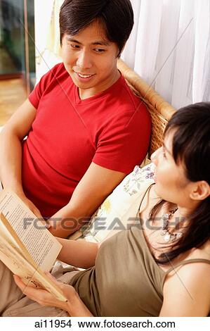 Couple on bed, side by side, woman with book View Large Photo Image Picture - Couple on bed, side by side, woman with book. Fotosearch