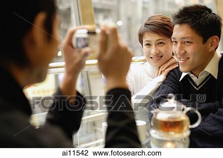 Couple posing as their friend takes their picture View Large Photo Image Stock Image - Couple posing as their friend takes their picture. Fotosearch