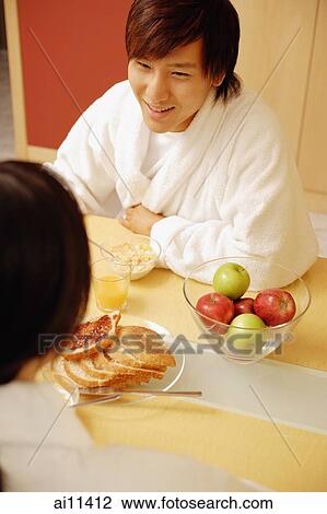 Couple sitting across breakfast table, face to face View Large Photo Image Stock Image - Couple sitting across breakfast table, face to face. Fotosearch
