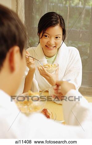 Couple sitting across each other having breakfast View Large Photo Image Stock Photo - Couple sitting across each other having breakfast. Fotosearch