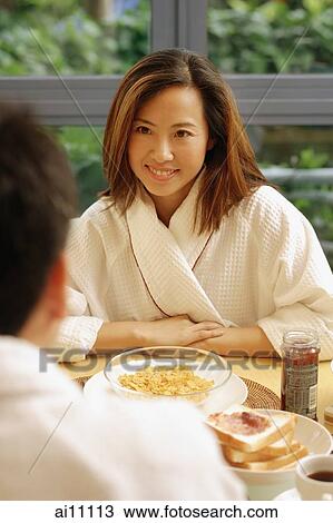 Couple sitting across from each other, breakfast in front of them. View Large Photo Image Stock Image - Couple sitting across from each other, breakfast in front of them.. Fotosearch