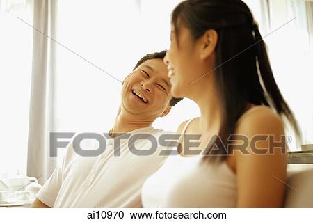 Couple sitting down side by side, laughing View Large Photo Image Stock Image - Couple sitting down side by side, laughing. Fotosearch
