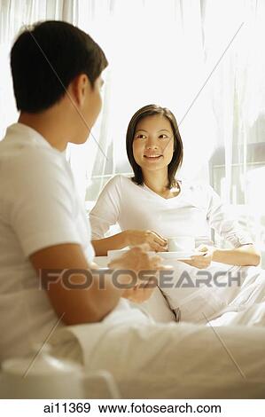 Couple sitting face to face, having coffee View Large Photo Image Stock Photo - Couple sitting face to face, having coffee. Fotosearch