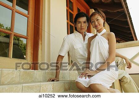Couple sitting on steps, looking at camera View Large Photo Image Stock Image - Couple sitting on steps, looking at camera. Fotosearch