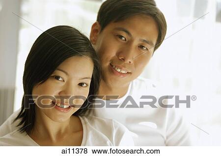 Couple sitting side by side, looking at camera View Large Photo Image Stock Photo - Couple sitting side by side, looking at camera. Fotosearch