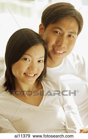 Couple sitting side by side, looking at camera View Large Photo Image Stock Photo - Couple sitting side by side, looking at camera. Fotosearch