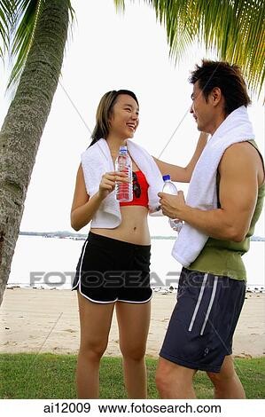 Stock Photo - Couple standing at beach, face to face. Fotosearch