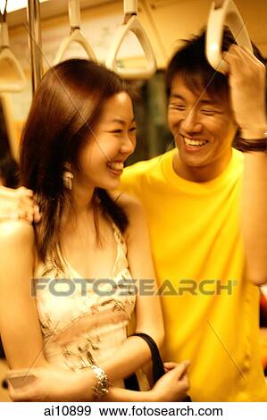 Couple standing in subway train View Large Photo Image Stock Photo - Couple standing in subway train. Fotosearch