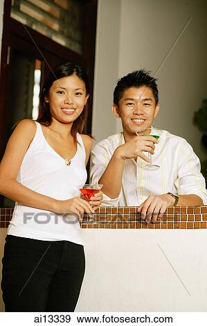 Stock Photo - Couple standing looking at camera. Fotosearch
