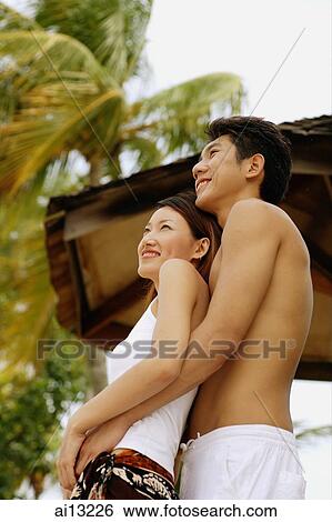 Couple standing, looking away, woman leaning on man View Large Photo Image Stock Photograph - Couple standing, looking away, woman leaning on man. Fotosearch