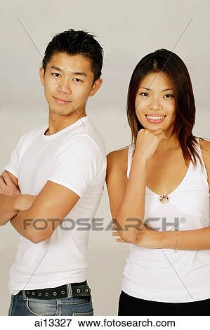 Couple standing next to each other, looking at camera View Large Photo Image Stock Photo - Couple standing next to each other, looking at camera. Fotosearch