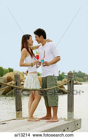 Couple standing on jetty, face to face View Large Photo Image Picture - Couple standing on jetty, face to face. Fotosearch