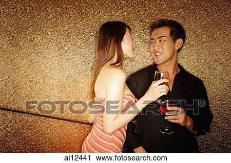 Couple standing with wine glass, face to face View Large Photo Image Stock Image - Couple standing with wine glass, face to face. Fotosearch