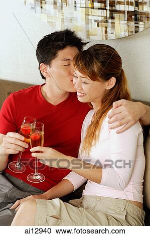 Couple toasting with champagne, man kissing woman on cheek View Large Photo Image Stock Image - Couple toasting with champagne, man kissing woman on cheek. Fotosearch
