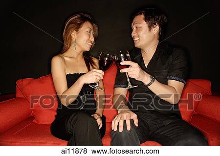 Couple toasting with drinks, sideview View Large Photo Image Stock Photo - Couple toasting with drinks, sideview. Fotosearch