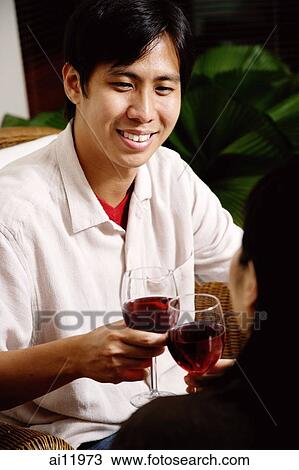 Couple toasting with wine glasses, man smiling View Large Photo Image Stock Image - Couple toasting with wine glasses, man smiling. Fotosearch
