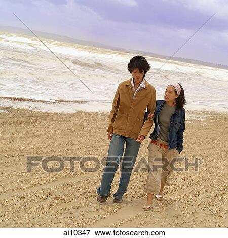 Couple walking along beach View Large Photo Image Stock Photo - Couple walking along beach. Fotosearch