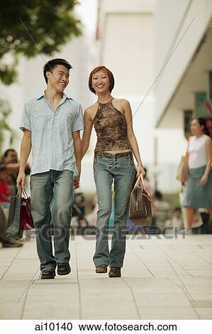 Couple walking in street, hand in hand View Large Photo Image Stock Image - Couple walking in street, hand in hand. Fotosearch