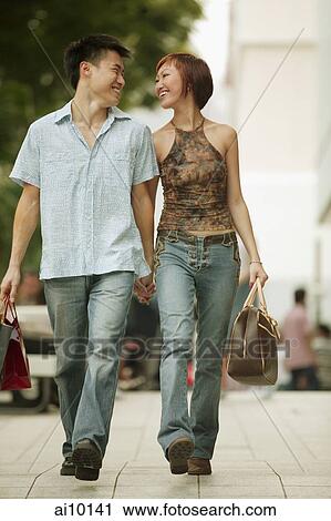 Couple walking in street, hand in hand View Large Photo Image Stock Image - Couple walking in street, hand in hand. Fotosearch