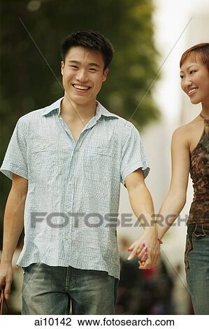 Couple walking in street, hand in hand View Large Photo Image Stock Image - Couple walking in street, hand in hand. Fotosearch