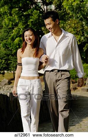 Couple walking through park, holding hands View Large Photo Image Stock Image - Couple walking through park, holding hands. Fotosearch