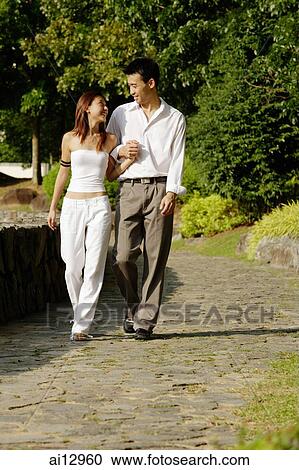 Couple walking through park, side by side, holding hands View Large Photo Image Stock Image - Couple walking through park, side by side, holding hands. Fotosearch