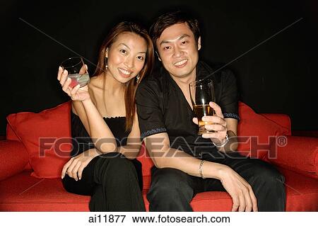 Stock Photo - Couple with drinks, looking at camera. Fotosearch