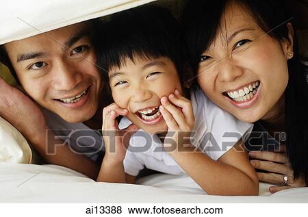 Couple with young daughter under sheets View Large Photo Image Stock Photo - Couple with young daughter under sheets. Fotosearch