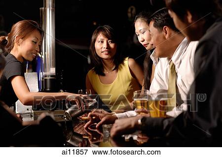 Couples at bar counter, bartender pouring drinks View Large Photo Image Stock Photo - Couples at bar counter, bartender pouring drinks. Fotosearch