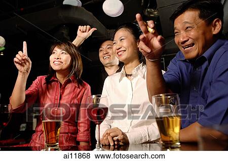 Couples at bar, making hand signs View Large Photo Image Stock Photo - Couples at bar, making hand signs. Fotosearch