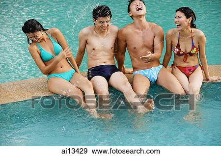 Couples at edge of swimming pool, sitting side by side laughing View Large Photo Image Stock Photo - Couples at edge of swimming pool, sitting side by side laughing. Fotosearch