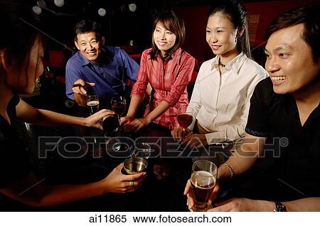 Couples drinking at bar, bartender serving them View Large Photo Image Stock Photography - Couples drinking at bar, bartender serving them. Fotosearch