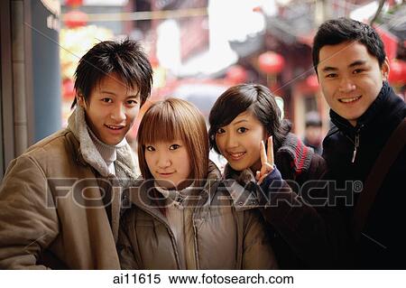 Couples looking at camera, one young woman making peace sign View Large Photo Image Stock Photography - Couples looking at camera, one young woman making peace sign. Fotosearch