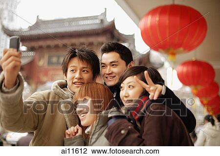 Couples looking at camera phone, making peace signs View Large Photo Image Stock Image - Couples looking at camera phone, making peace signs. Fotosearch