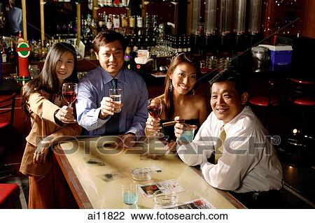 Couples raising wine glasses, looking at camera View Large Photo Image Stock Image - Couples raising wine glasses, looking at camera. Fotosearch