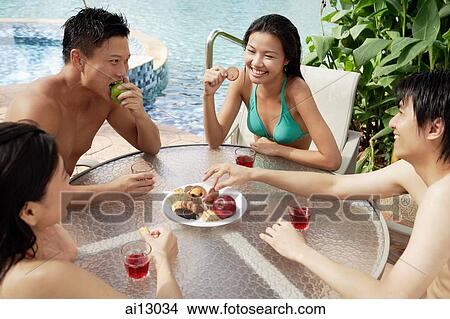 Couples sitting and snacking at poolside table View Large Photo Image Picture - Couples sitting and snacking at poolside table. Fotosearch