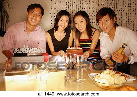 Couples sitting down, looking at camera, cake in front of them View Large Photo Image Stock Photo - Couples sitting down, looking at camera, cake in front of them. Fotosearch