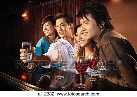 Couples using camera phone to take a picture View Large Photo Image Stock Image - Couples using camera phone to take a picture. Fotosearch
