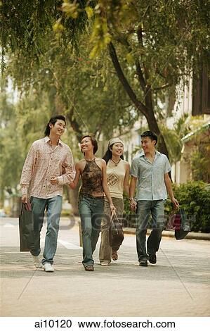 Couples walking hand in hand, carrying shopping bags View Large Photo Image Stock Image - Couples walking hand in hand, carrying shopping bags. Fotosearch