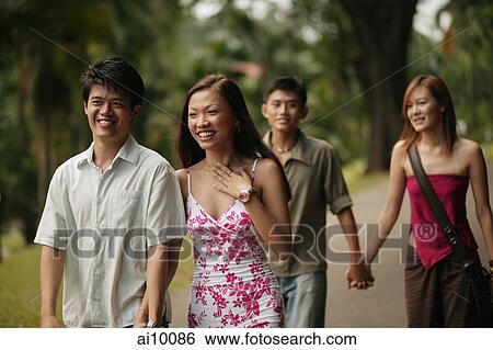 Couples walking hand in hand in park View Large Photo Image Stock Photograph - Couples walking hand in hand in park. Fotosearch