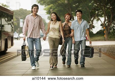 Couples walking together, carrying shopping bags View Large Photo Image Picture - Couples walking together, carrying shopping bags. Fotosearch