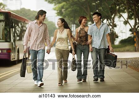 Couples walking together, carrying shopping bags View Large Photo Image Stock Image - Couples walking together, carrying shopping bags. Fotosearch
