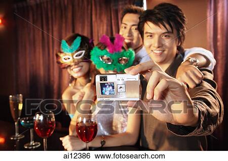 Couples with masks taking a picture with camera View Large Photo Image Stock Photograph - Couples with masks taking a picture with camera. Fotosearch
