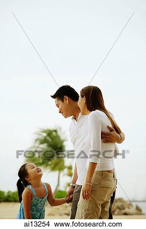 Daughter looking up at mother and father View Large Photo Image Picture - Daughter looking up at mother and father. Fotosearch