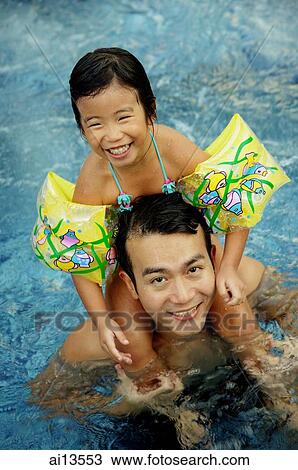 Daughter sitting on shoulders of father, in swimming pool View Large Photo Image Stock Image - Daughter sitting on shoulders of father, in swimming pool. Fotosearch