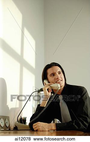 Stock Photo - Executive at desk, on the phone. Fotosearch