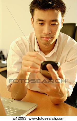 Executive at office desk using PDA View Large Photo Image Stock Image - Executive at office desk using PDA. Fotosearch
