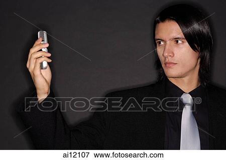 Stock Photo - Executive holding mobile phone, photo messaging. Fotosearch