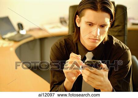 Executive in office using PDA, portrait View Large Photo Image Stock Photo - Executive in office using PDA, portrait. Fotosearch