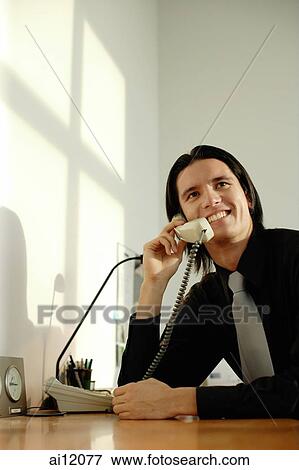 Executive in the office, using phone View Large Photo Image Stock Photo - Executive in the office, using phone. Fotosearch